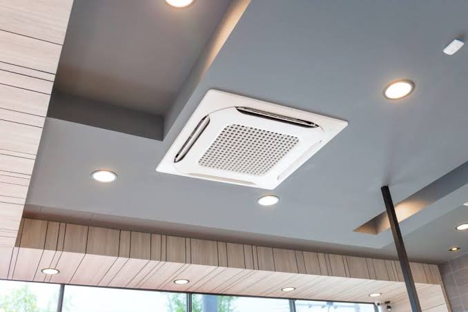 Technicien effectuant la maintenance d'une unité HVAC en toiture